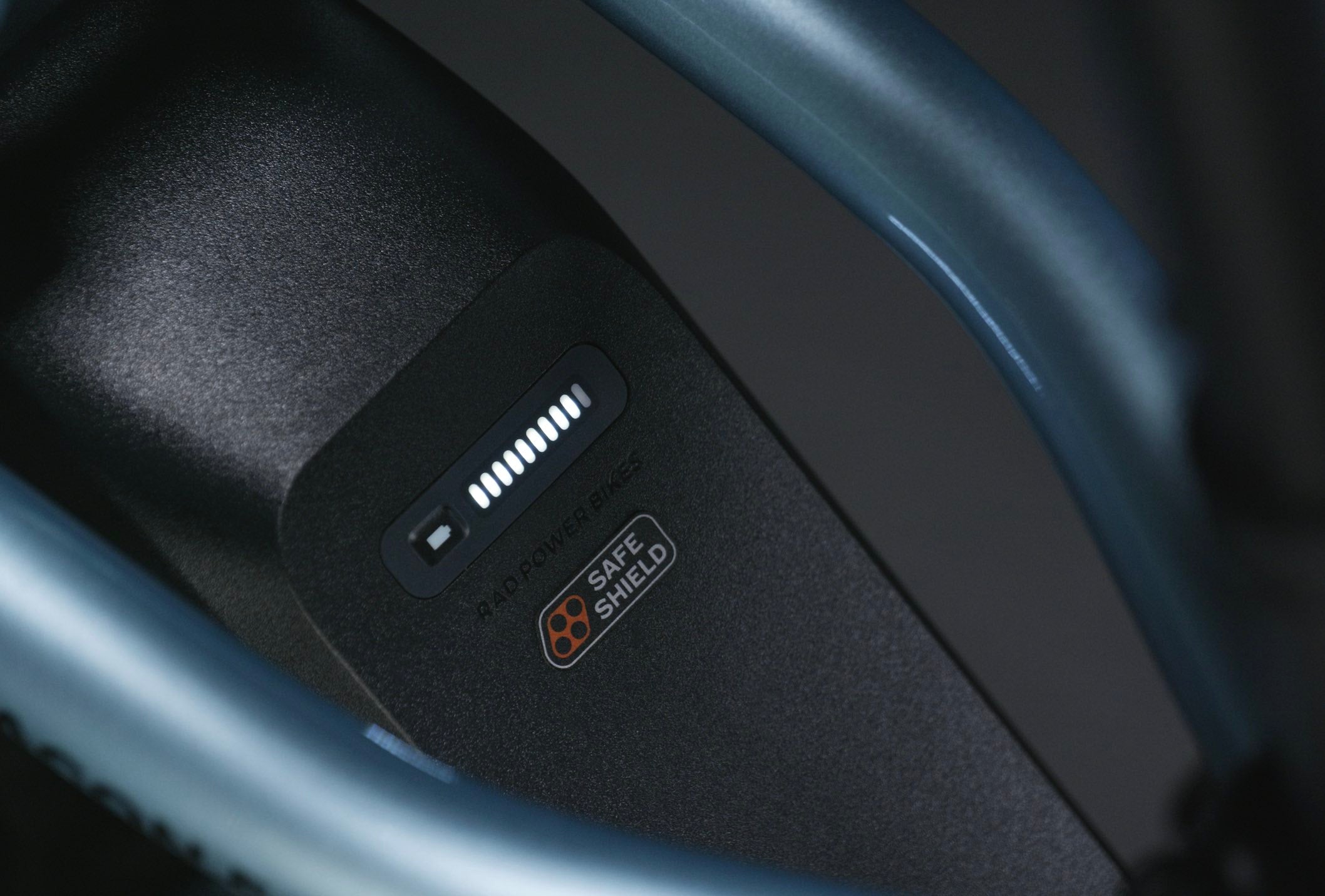 A close-up of a Safe Shield Battery on a blue ebike.