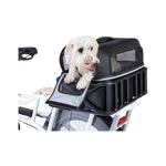 A small dog looking through the door of a black rectangular bag that is inside a bike basket. 